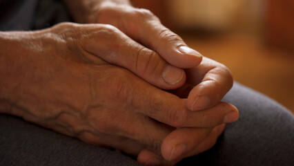 Fototapeta premium The older man's hands are on his knees, waiting.