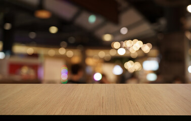 Mock up for space. Empty dark wooden table in front of abstract blurred bokeh background of restaurant . can be used for display or montage your product