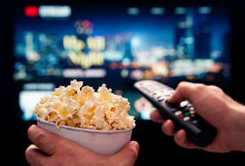Tv movie night with family. Stream VOD platform. Popcorn and remote control. Video entertainment...