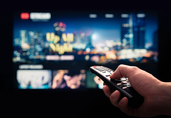 Watching movie stream service on tv. Video on demand subscription service and platform in television. Streaming series, films and shows online. Man using remote control. Person browsing mockup VOD. - obrazy, fototapety, plakaty