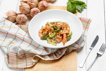 Fitness dish with grilled shrimp and zucchini on wooden white vintage background
