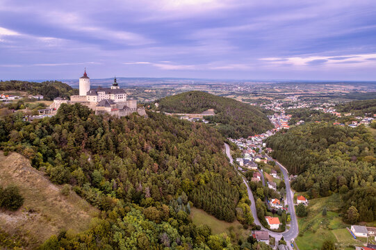 The medieval Forchtenstein Castle on the hilltop surrounded by dense forest below an overcast autumn sky 