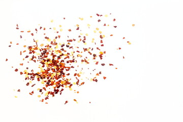 hot red chili pepper flakes burst in white background as food background,top view with copy space - obrazy, fototapety, plakaty