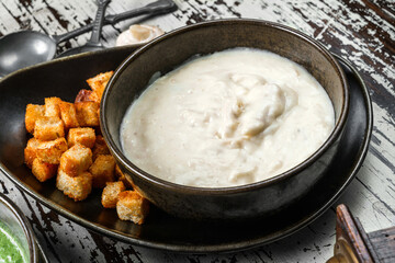 Mushroom cream soup with croutons in bowl on rustic wooden background. Close up