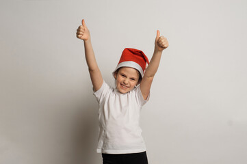 Smiling funny kid in red Santa cap headwear runs for gifts. Christmas concept. Isolated on white.