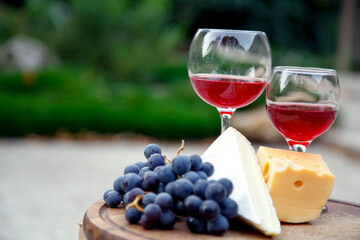 Composition with a glass of red wine, grapes and cheese. Red natural wine, cheese and a bunch of...