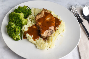 seasoned chicken breast  on mashed potatoes with gravy