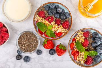 Bowl of granola with yogurt and fresh berries on a texture table. Yogurt berries, acai bowl,...
