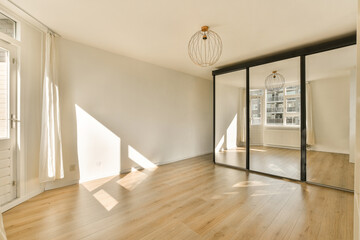 an empty living room with wood flooring and large sliding door leading to the balcony area in this apartment building