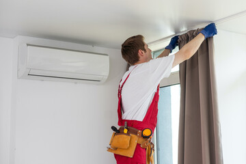 A handyman installing new cornice for curtains, home repair and renovation works.