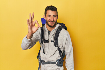Young Hispanic man ready for hiking cheerful and confident showing ok gesture.