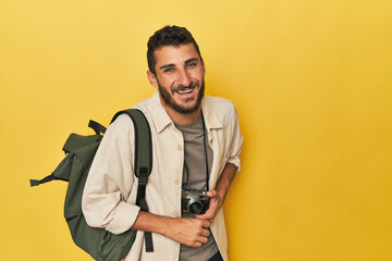 Young Hispanic travel photographer poses laughing and having fun.