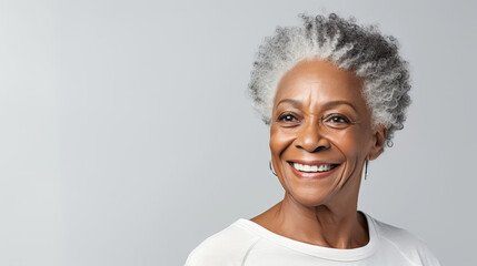 A close-up studio portrait captures the grace of a senior African American woman with grey hair, isolated on a white background, showcasing her timeless beauty.