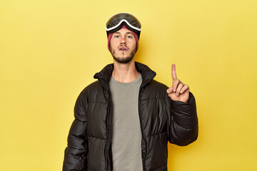 Obraz premium Man in winter coat with snow goggles on yellow having some great idea, concept of creativity.