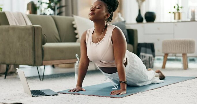 Yoga, laptop and zen with a black woman on the floor of a living room in her home for health or wellness. Exercise, computer and mental health with a young person in her apartment for mindfulness