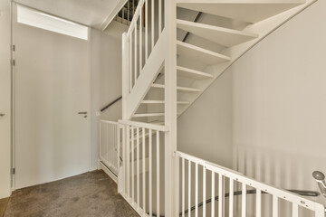 a stairway way in a house with white railings on the sides and stairs leading up to the second floor