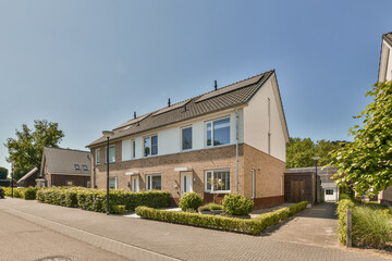 a street with houses and trees in the fore, taken from an angle on a clear blue sky overcasted day