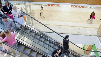 People going shopping, moving on escalator in city mall, carrying many bags, going shopping. Crowded people in shopping mall. Big sales. Concept of shopping, Black Friday, city mall, leisure time