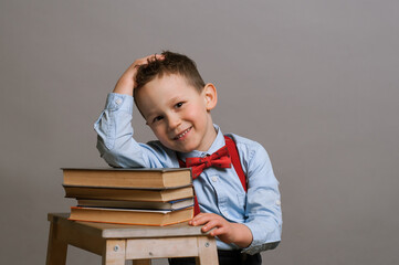Sleeping elementary aged boy sitting at the desk with books