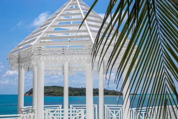 White carved gazebo on the seashore in a tropical country. Holidays in Asia