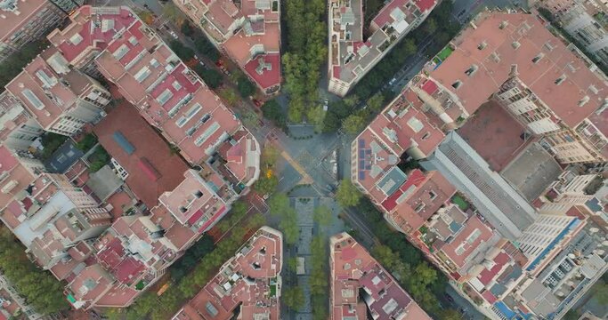 Aerial birds eye view of rectangular red roof buildings architecture cityscape and traffic in Barcelona. Drone shot over urban streets grid of typical apartment blocks in city centre. Catalonia, Spain