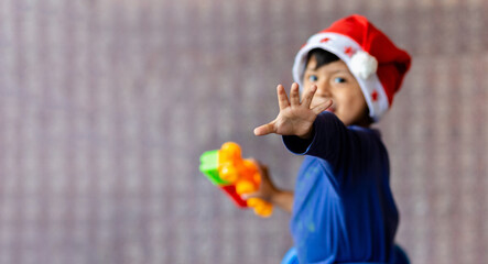 A Latin boy with a sweet smile and a Christmas hat looking at the camera. Copy space.
