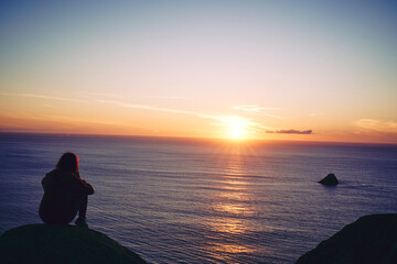 Captivated by the Evening Glow: A Young Girl Watching the Setting Sun