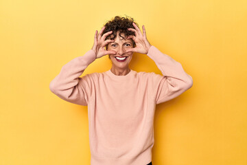 Mid-aged caucasian woman on vibrant yellow keeping eyes opened to find a success opportunity.