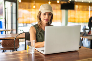 Mature woman using laptop in cafe