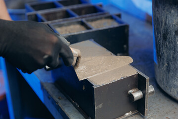 Worker making cube concrete casting by steel mould for control quality cement in building lab