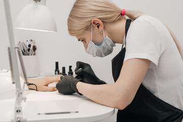 Close-up image of woman having her nails done in beauty salon