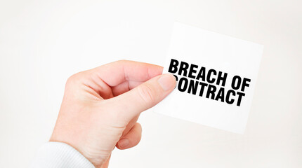 Businessman holding a card with text BREACH OF CONTRACT, business concept