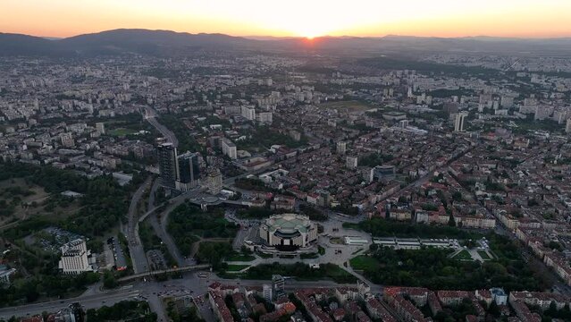 4K Aerial view of sunset or sunrise of the center of the capital of Bulgaria - Sofia. Architectural and emblematic buildings from the communist era, NDK - National Palace of Culture. Night lights