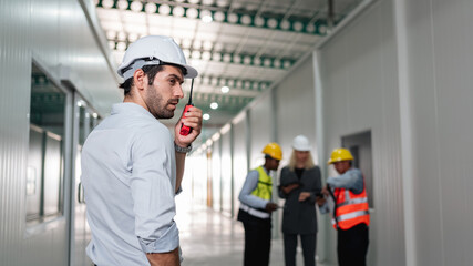 Portrait of engineers workers using talkie talking in empty warehouse to design the arrangement of...