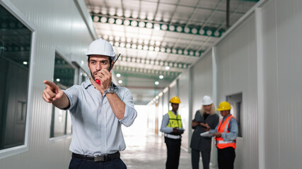 Portrait of engineers workers using talkie talking in empty warehouse to design the arrangement of product shelves..