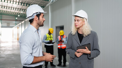 Team engineers workers planning and talking in empty warehouse to design the arrangement of product...