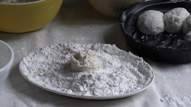 Southern biscuits being dredged in flour and buttered