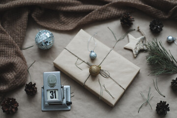 Christmas composition. New Year eve. December 31 on calendar on a craft paper background with spruce branches and a glowing garland. New year's date. Flat lay, top view