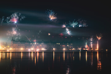 New Year's Eve midnight fireworks over the promenade of Peterhausen, taken from the waterfront next to the Steigenberger Peninsula. Constance (Konstanz), Lake Constance, Baden-Württemberg, Germany.