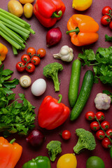 Fototapeta na wymiar Fresh vegetables, greenery and fruits on burgundy background