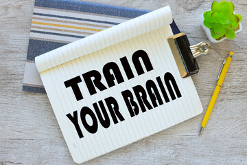 Train Your Brain. top view of a page with text. two notepads on the table