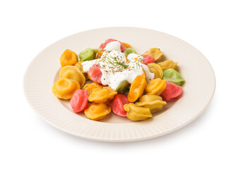 Plate of boiled colorful dumplings with sour cream and dill on white background