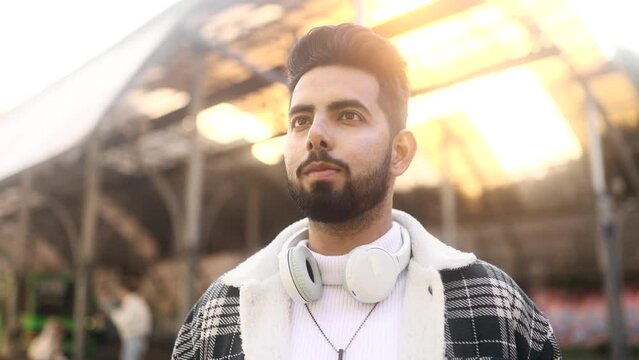 Handsome thoughtful inspired young man at the city street and enjoying beautiful day outdoors Attractive male tourist looking around at urban town while travel alone. High quality 4k footage