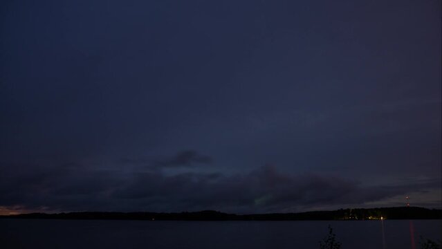 Time lapse of cloud movement over a lake in Finland in evening with forests in the horizon
