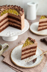 Chocolate cake decorated with chocolate ganache cream and chopped pistachios.