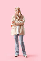 Mature Muslim woman in stylish clothes on pink background
