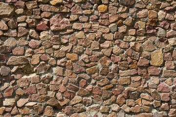 Texture of a stone wall made of red stone.