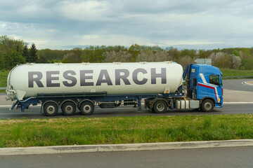 On a tank truck driving along the road there is an inscription - RESEARCH