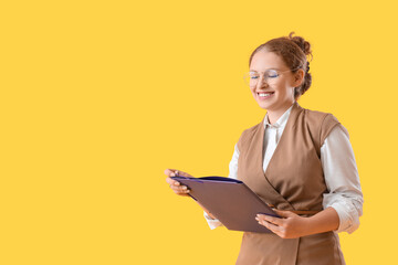 Young businesswoman with document folder on yellow background