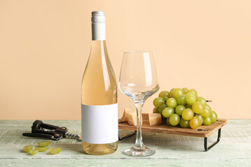 Obraz premium Glass and bottle of tasty wine with blank label on green wooden table